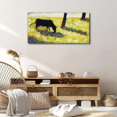 A cow grazing in a green landscape Print on canvas