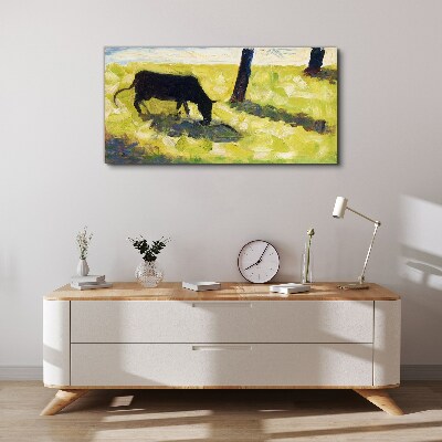 A cow grazing in a green landscape Print on canvas