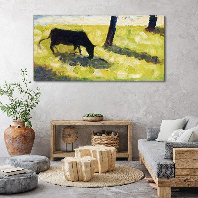 A cow grazing in a green landscape Print on canvas