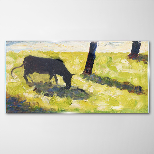 A cow grazing in a green landscape Glass art print