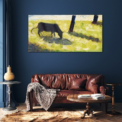 A cow grazing in a green landscape Glass art print
