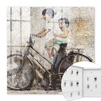 Key cabinet Children and a bicycle against an old wall
